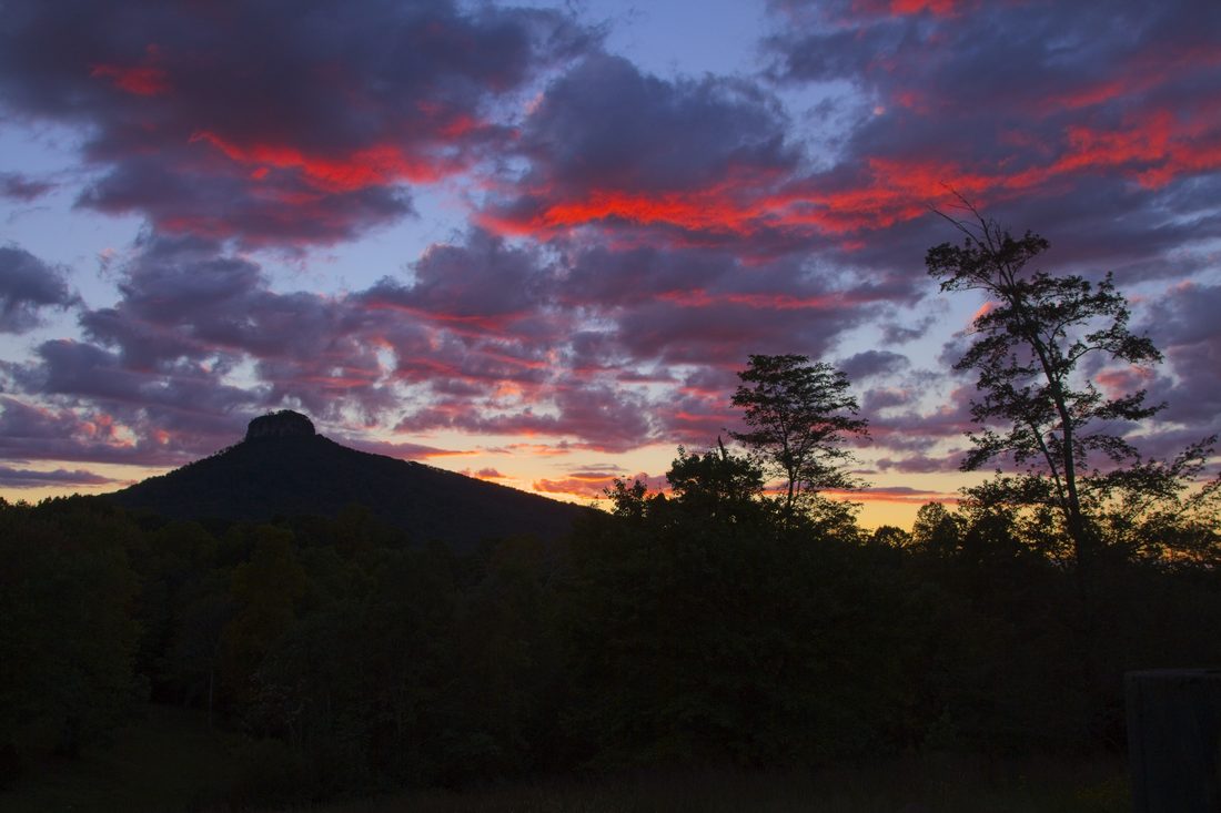 Fiery clouds over Pilot Mountain silhouette at sunset